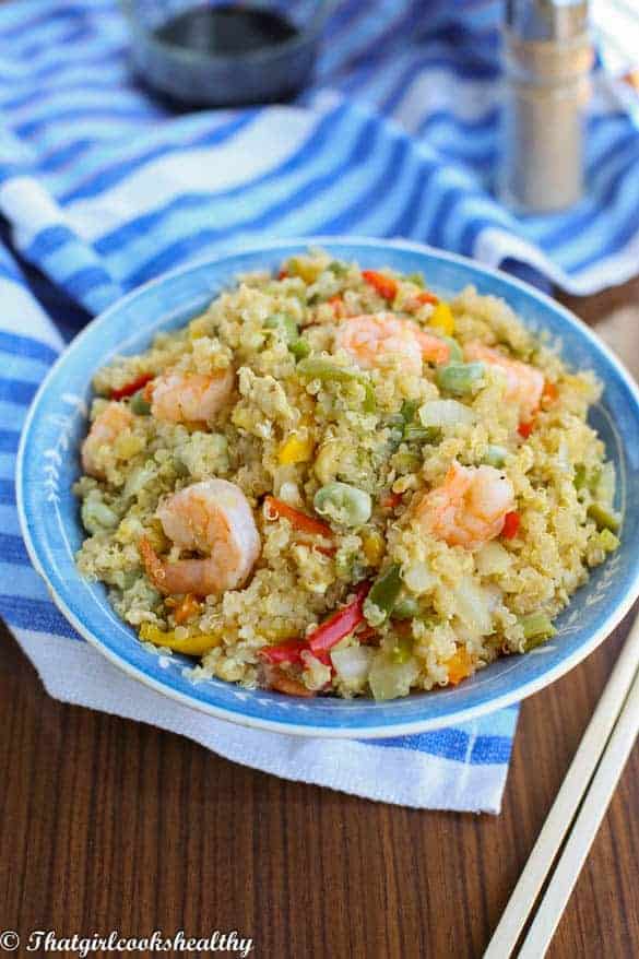 angle shot of shrimp and quinoa in a blue bowl