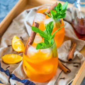 2 drinks with cinnamon sticks and pieces of orange