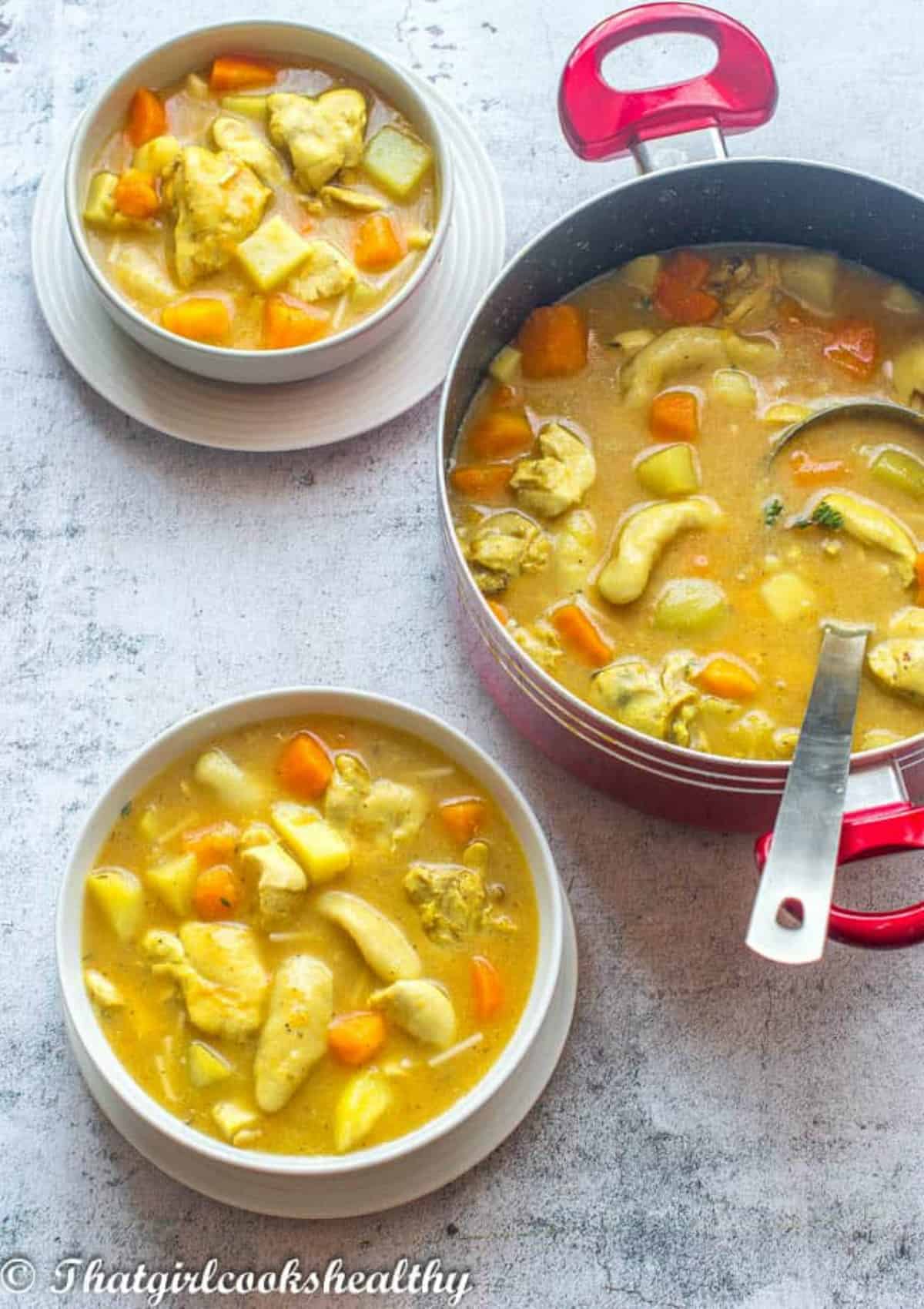 Two bowls with large pot of soup