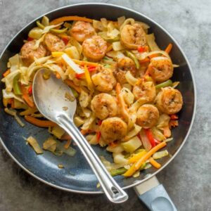 shrimp, cabbage and spoon in the skillet