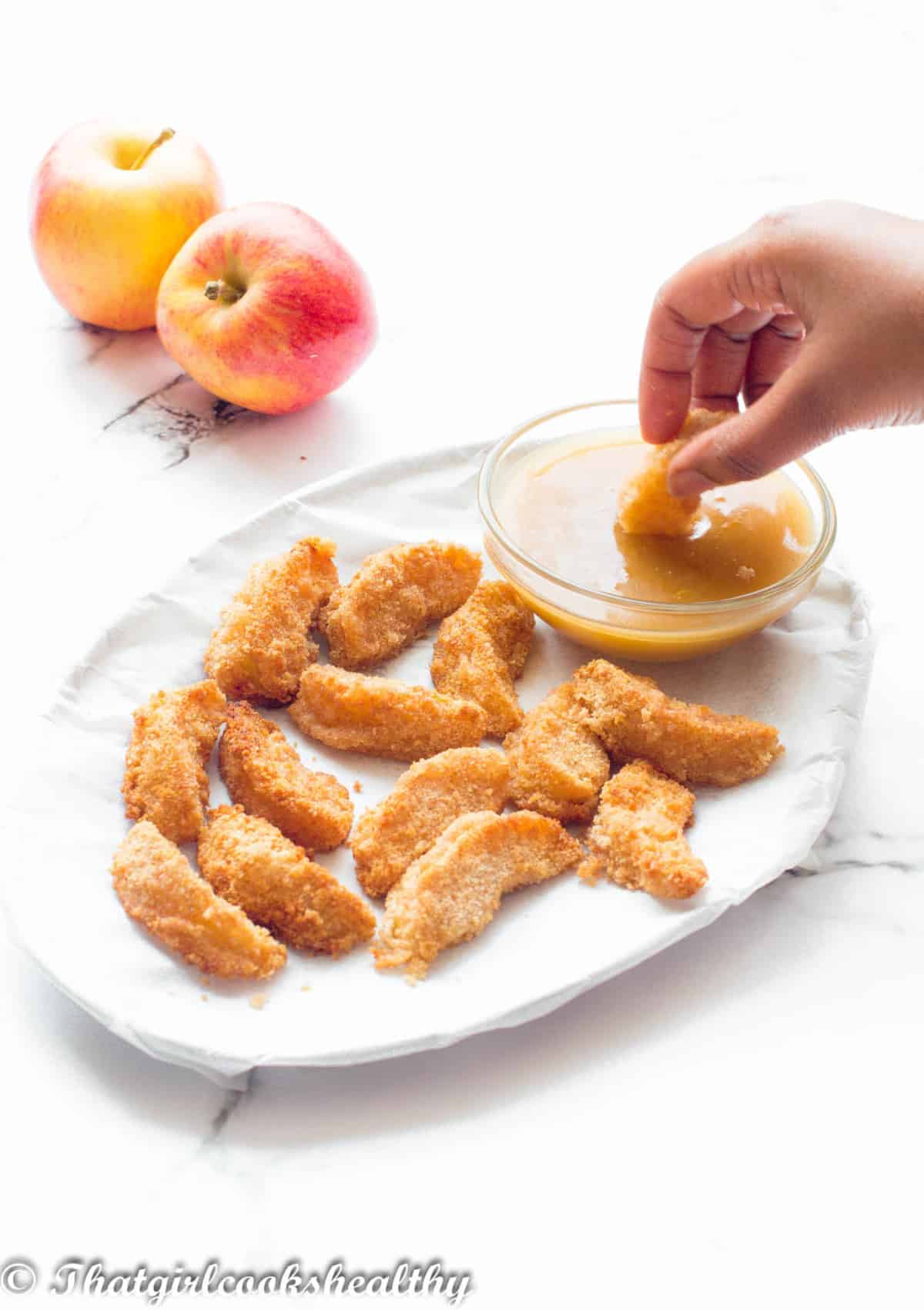 Dipping apple wedge into sauce