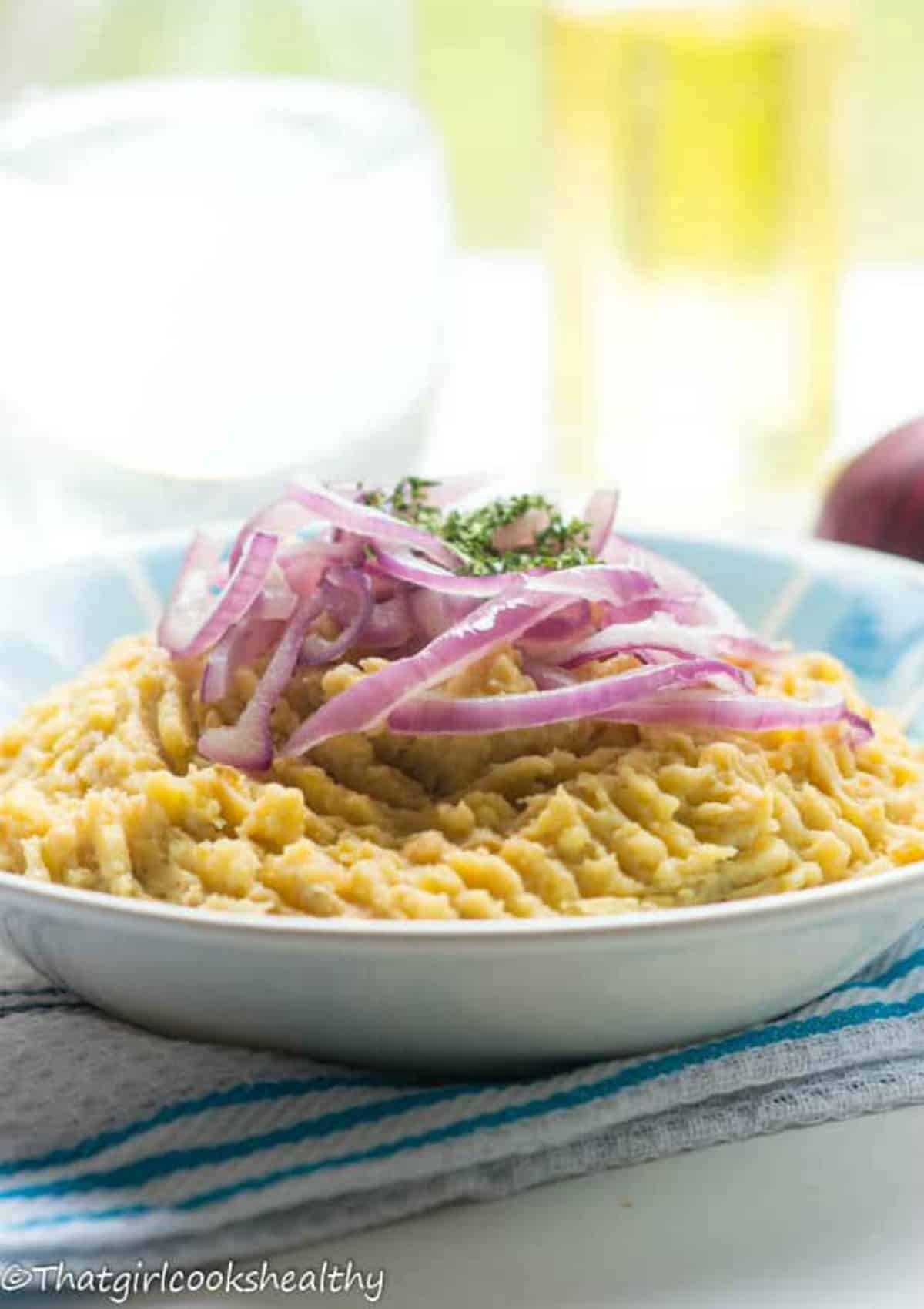 Mashed plantain with red onion garnish