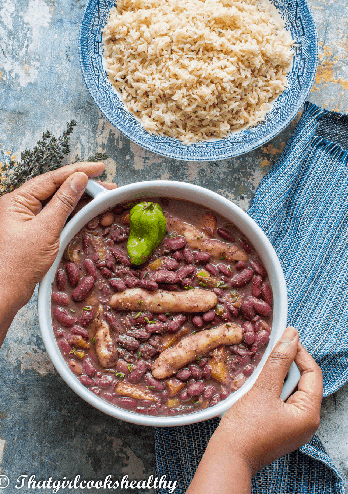 hands holding the casserole pot with brown rice above