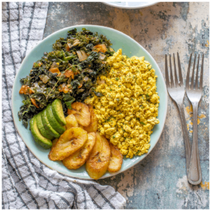 Plate of tofu scramble, green, plantain and avocado