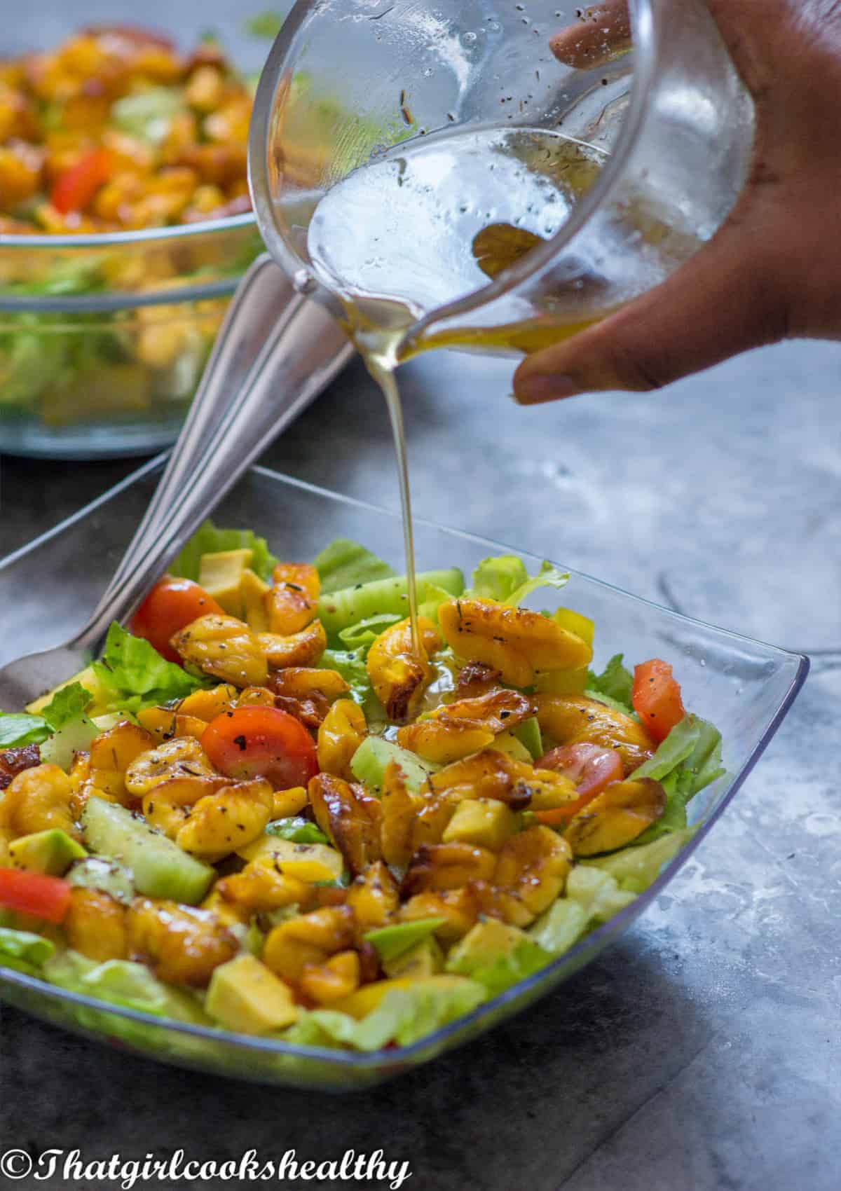 pouring dressing onto the salad