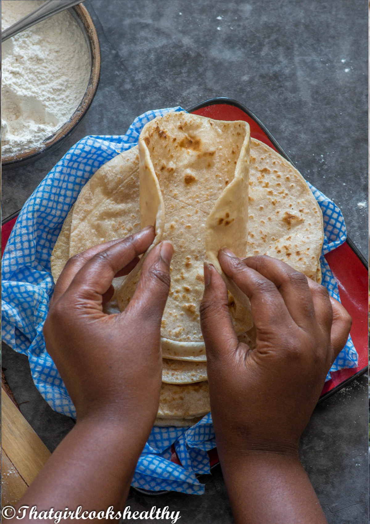 hands folding the roti together