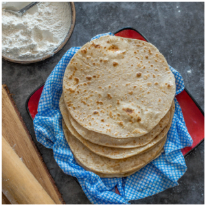 A pile of roti on a blue damp cloth