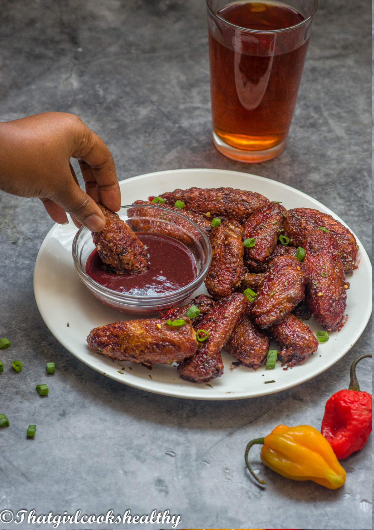 dipping chicken wing into the sorrel sauce