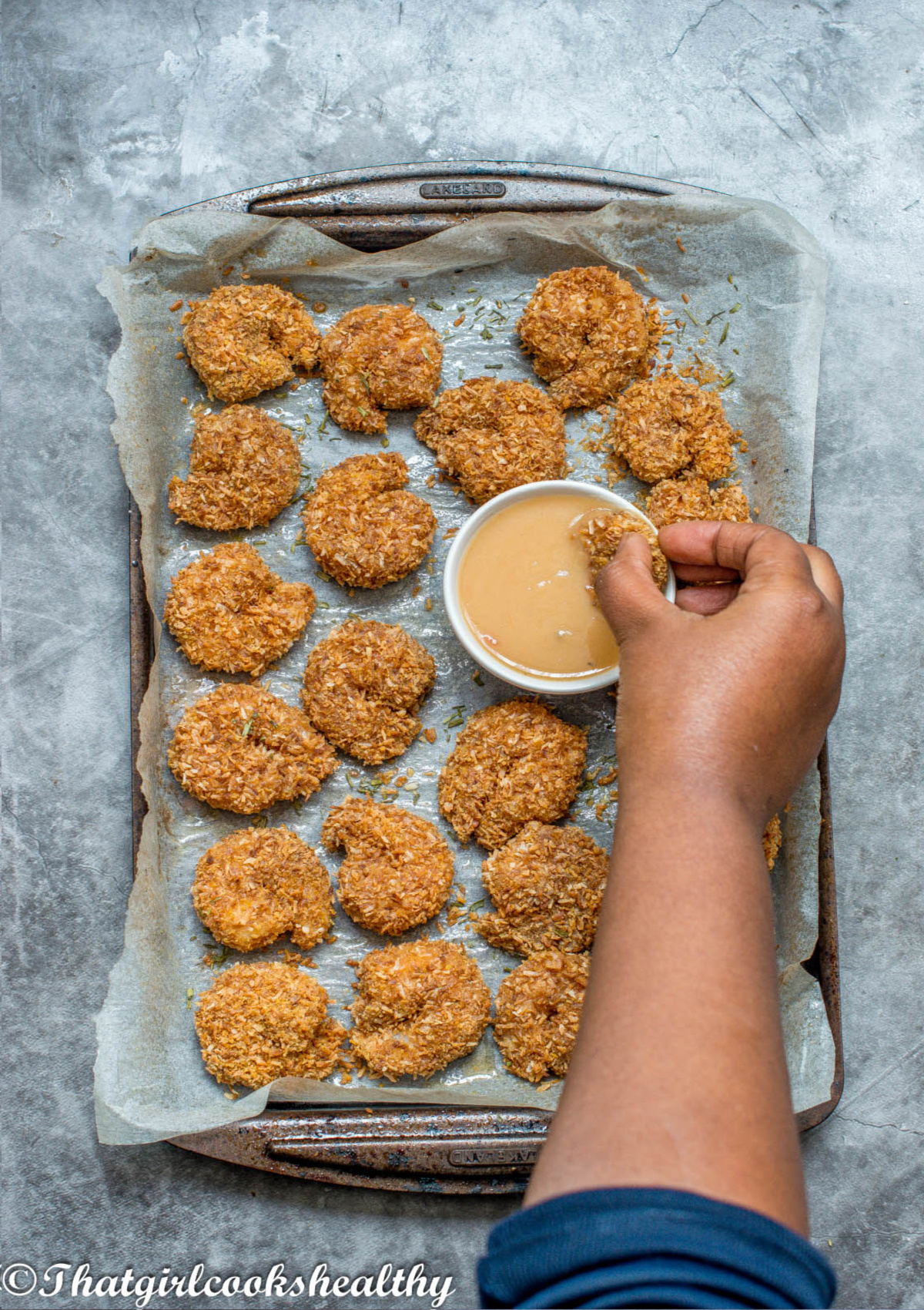 hand dipping a shrimp into the sauce