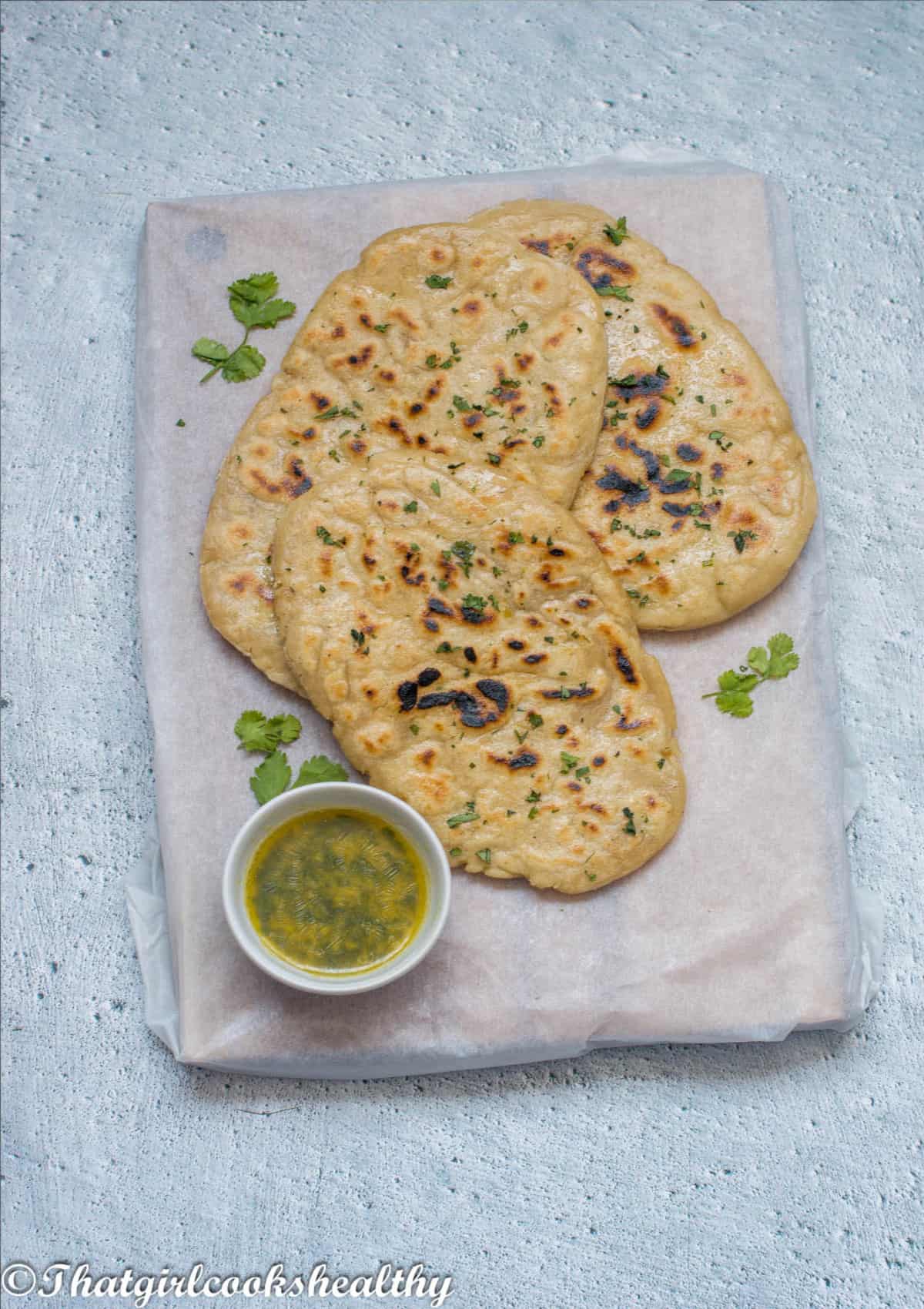 3 naan bread on a chopping board with butter