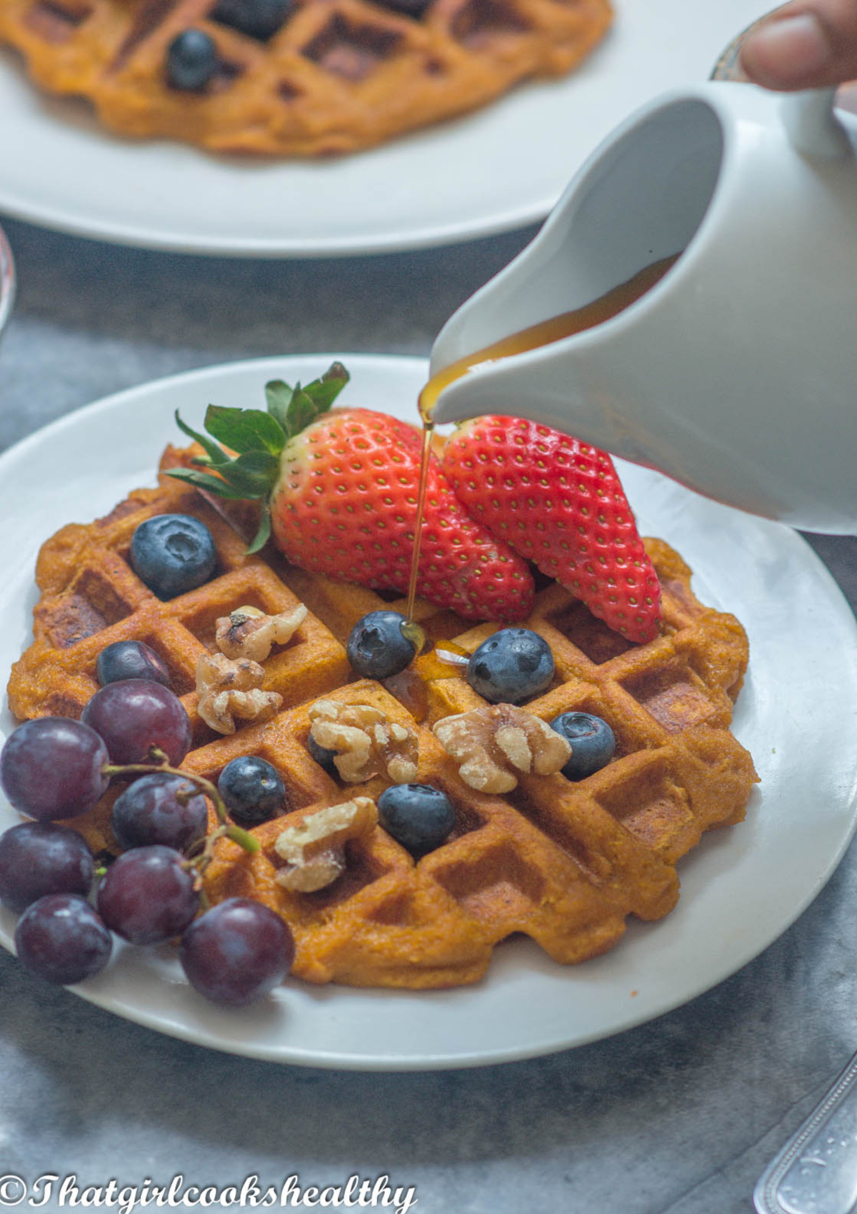 pouring syrup onto the waffle