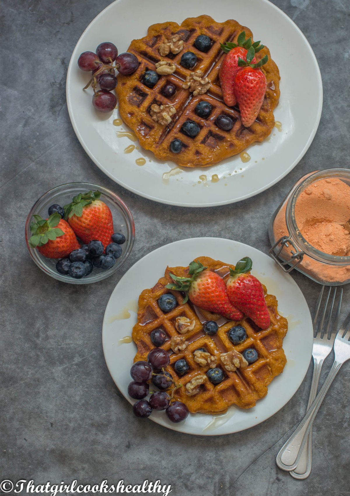 2 plates of waffles with garnished fruit on top