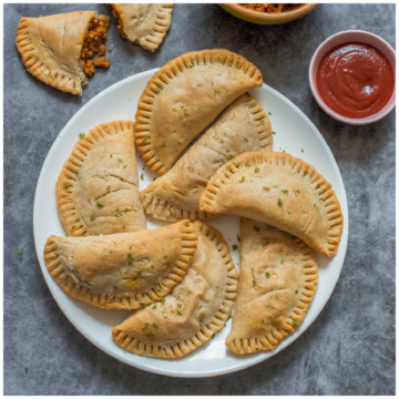 7 empanadas on a white plate