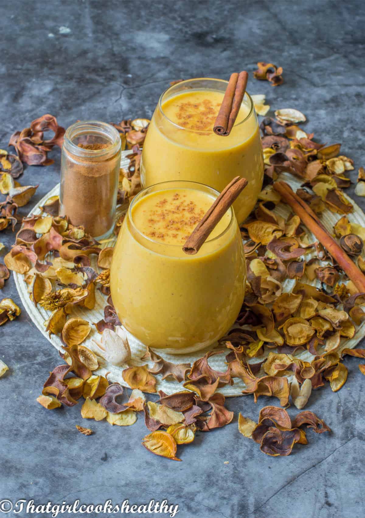 Two smoothies with cinnamon sticks on top.