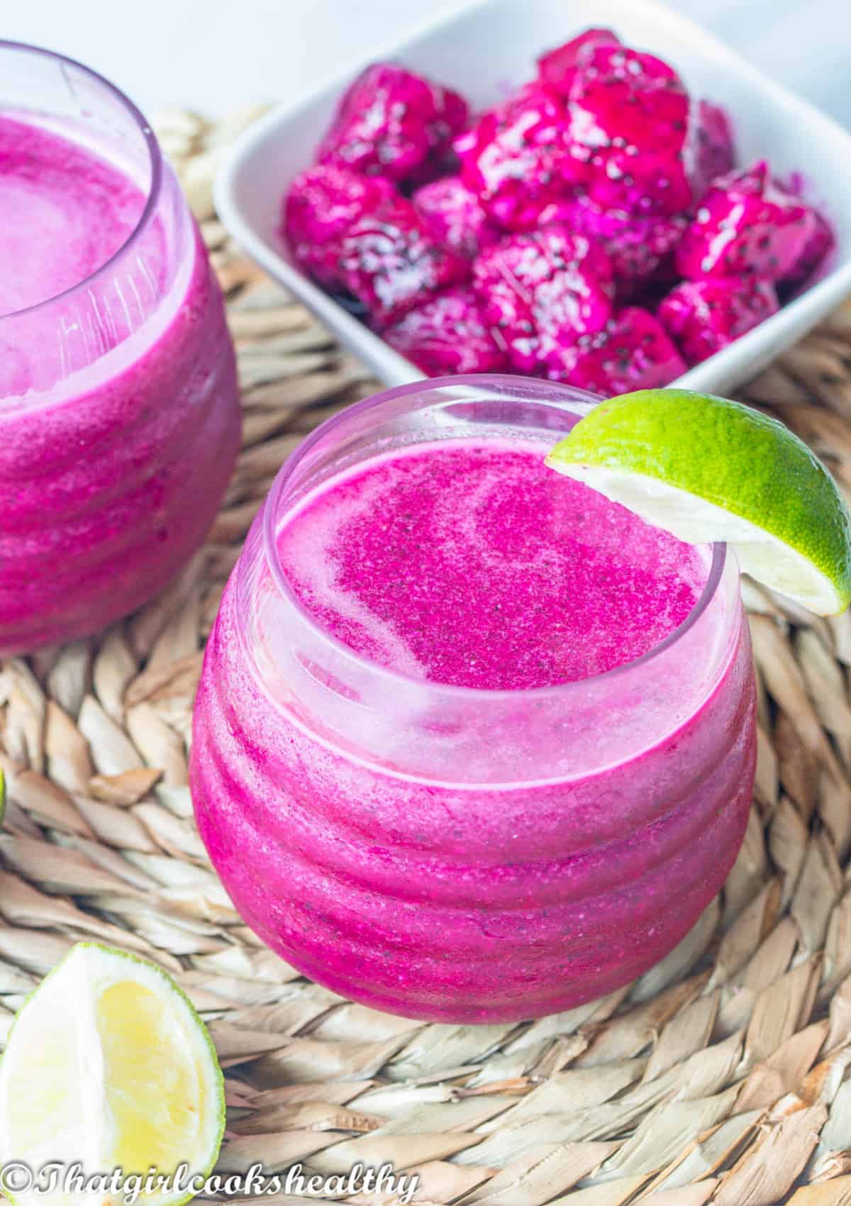 Dragon fruit juice with a piece of lime on the side