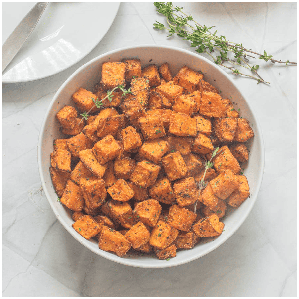 A bowl of sweet potato cubes with garnish