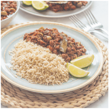 Picadillo, brown rice and lime on a plate