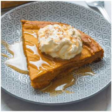 A slice of pumpkin pie with whipped coconut cream.