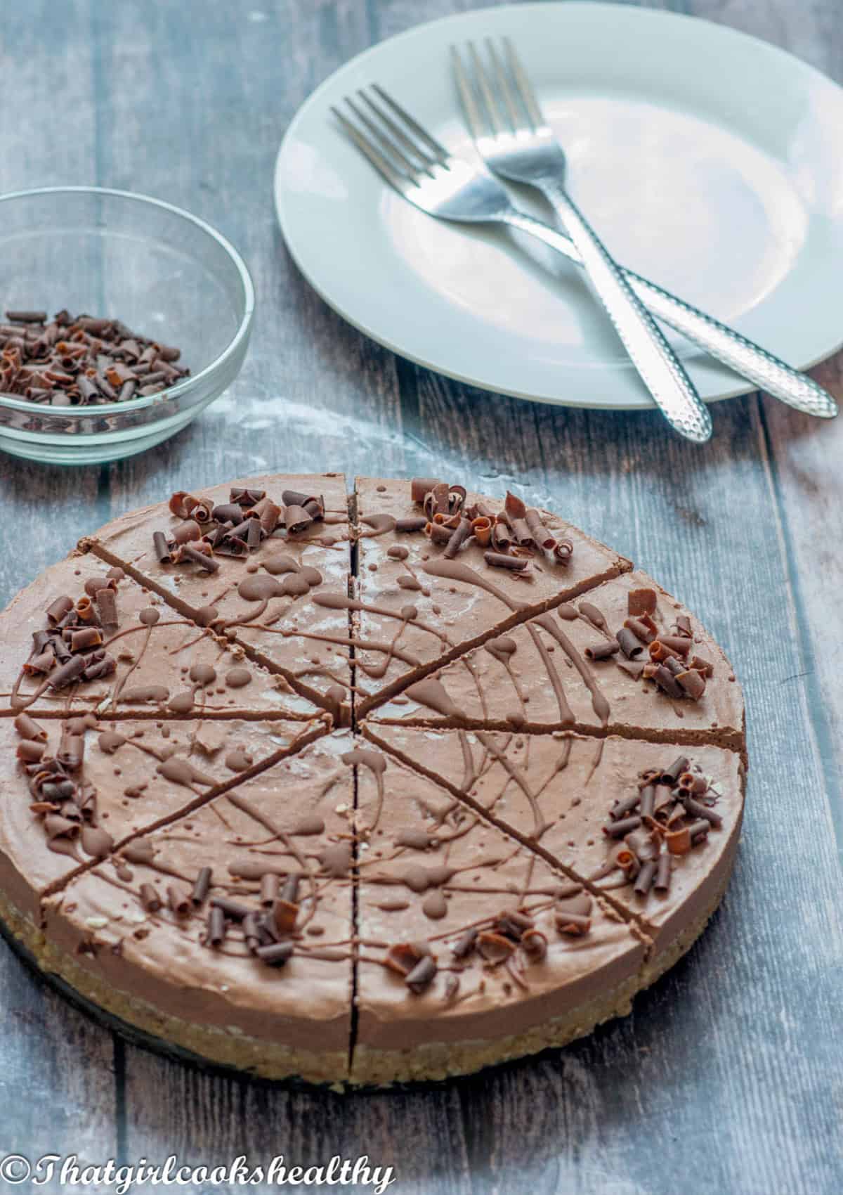 2 forks on a plate next to the cheesecake.