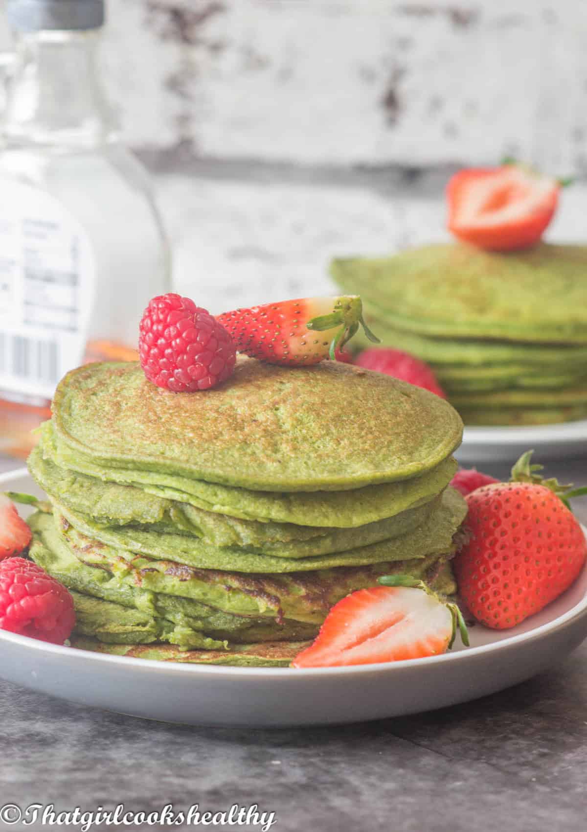 A stack of pancakes with fruit garnish.