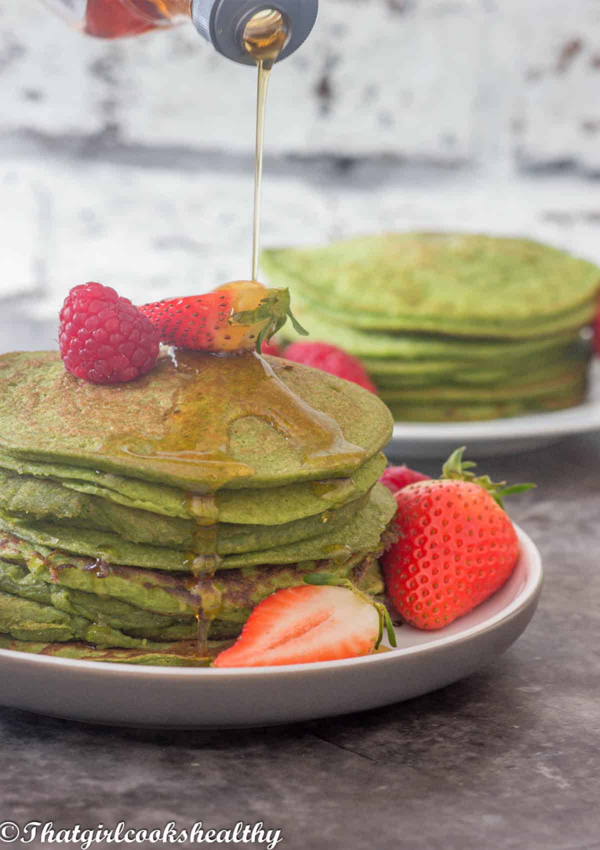 Syrup drizzled onto a stack of pancakes.
