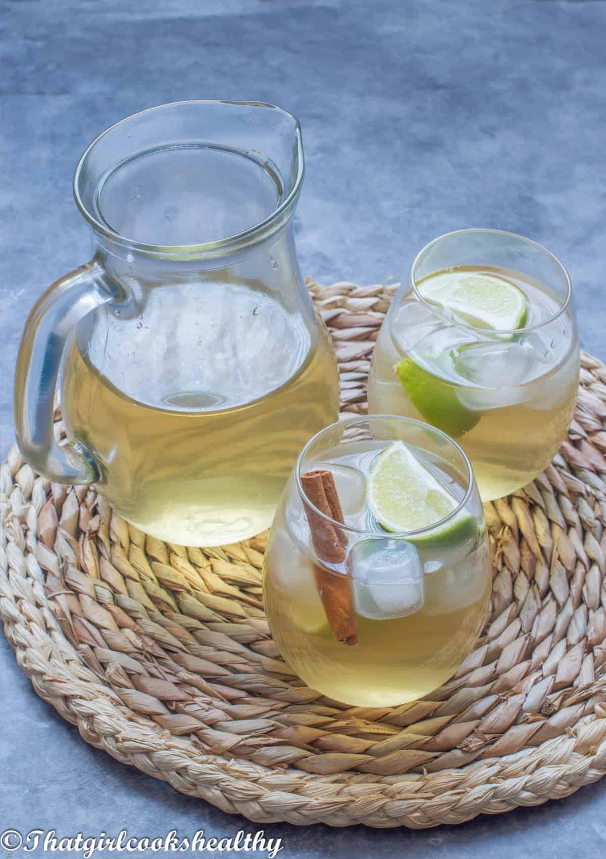 Two small glasses of mauby with a jug.