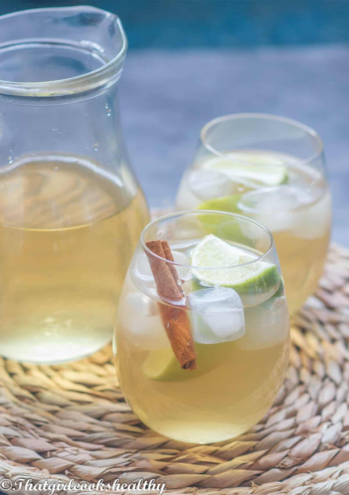 Mauby drink in a glass with ice and a cinnamon stick.