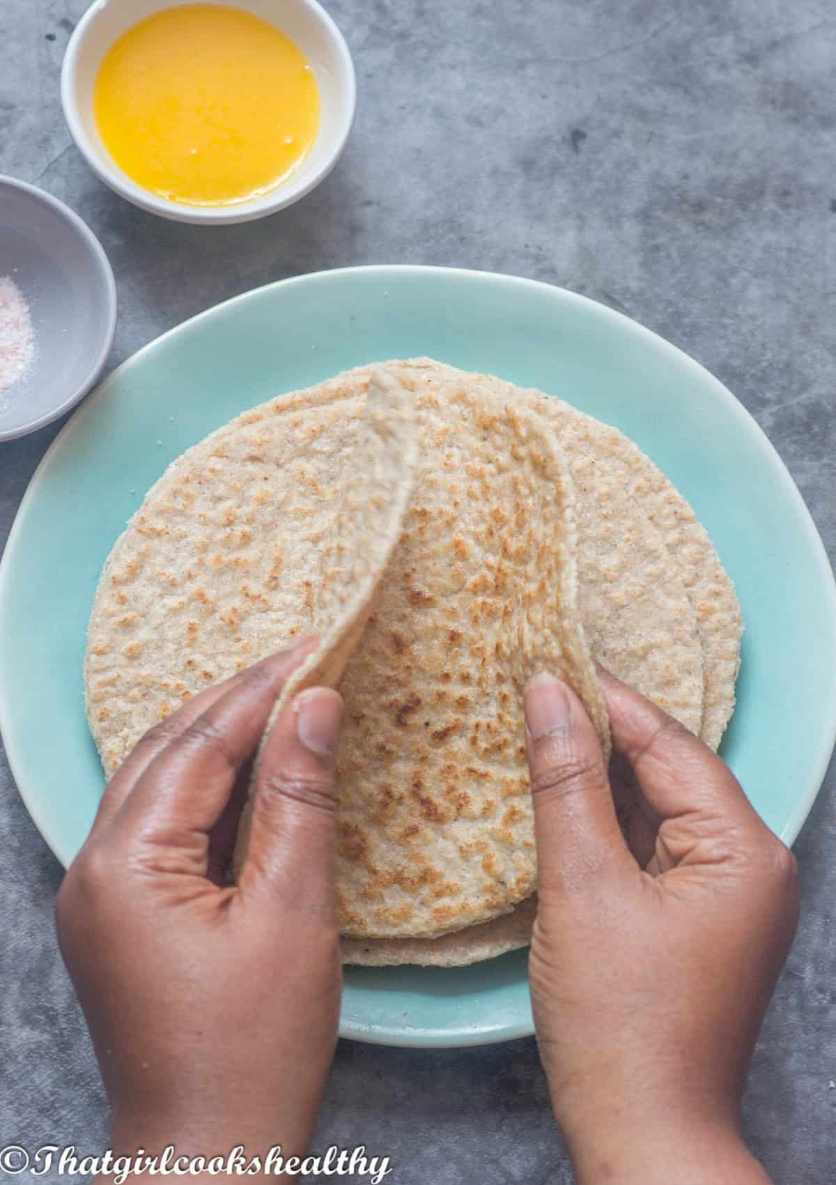 2 hands folding the roti