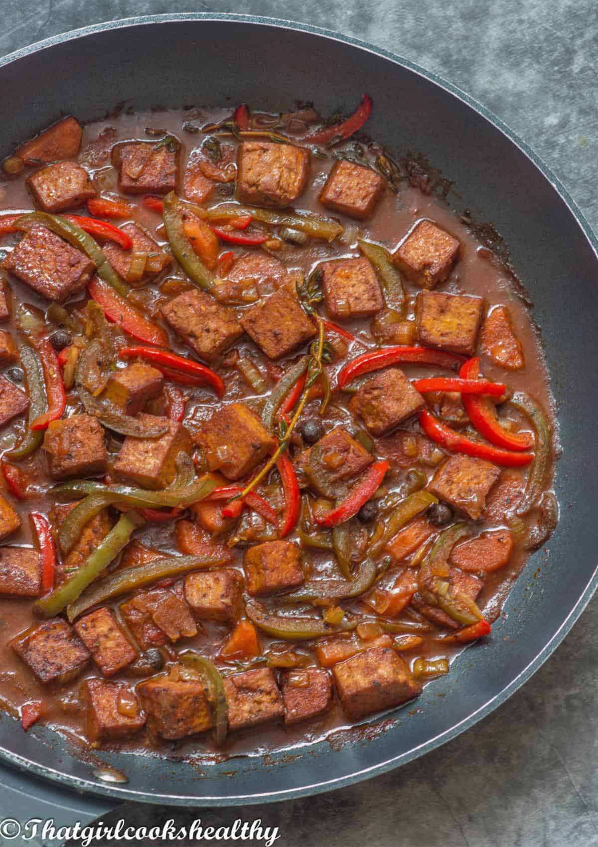 Close up of the stewed tofu in a frying pan with vegetables.