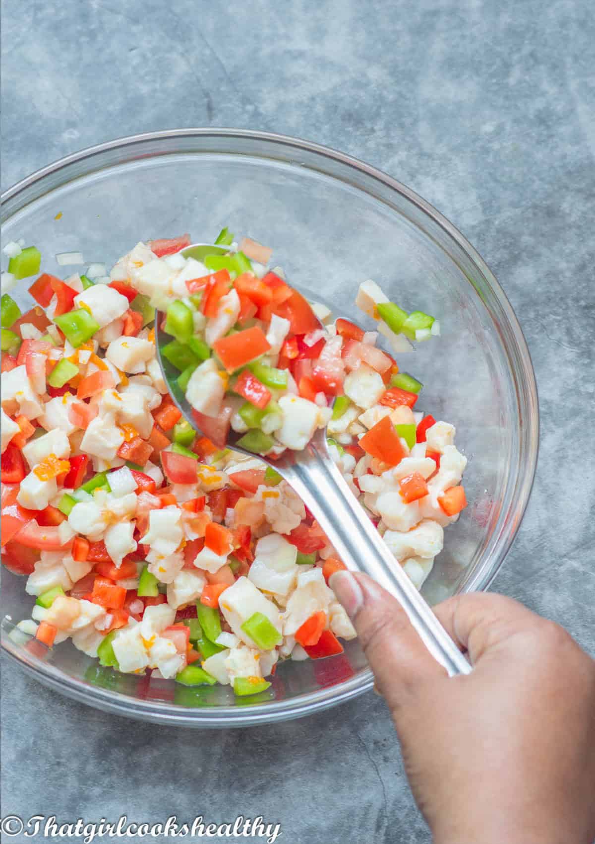 Hand scooping up the salad with a spoon