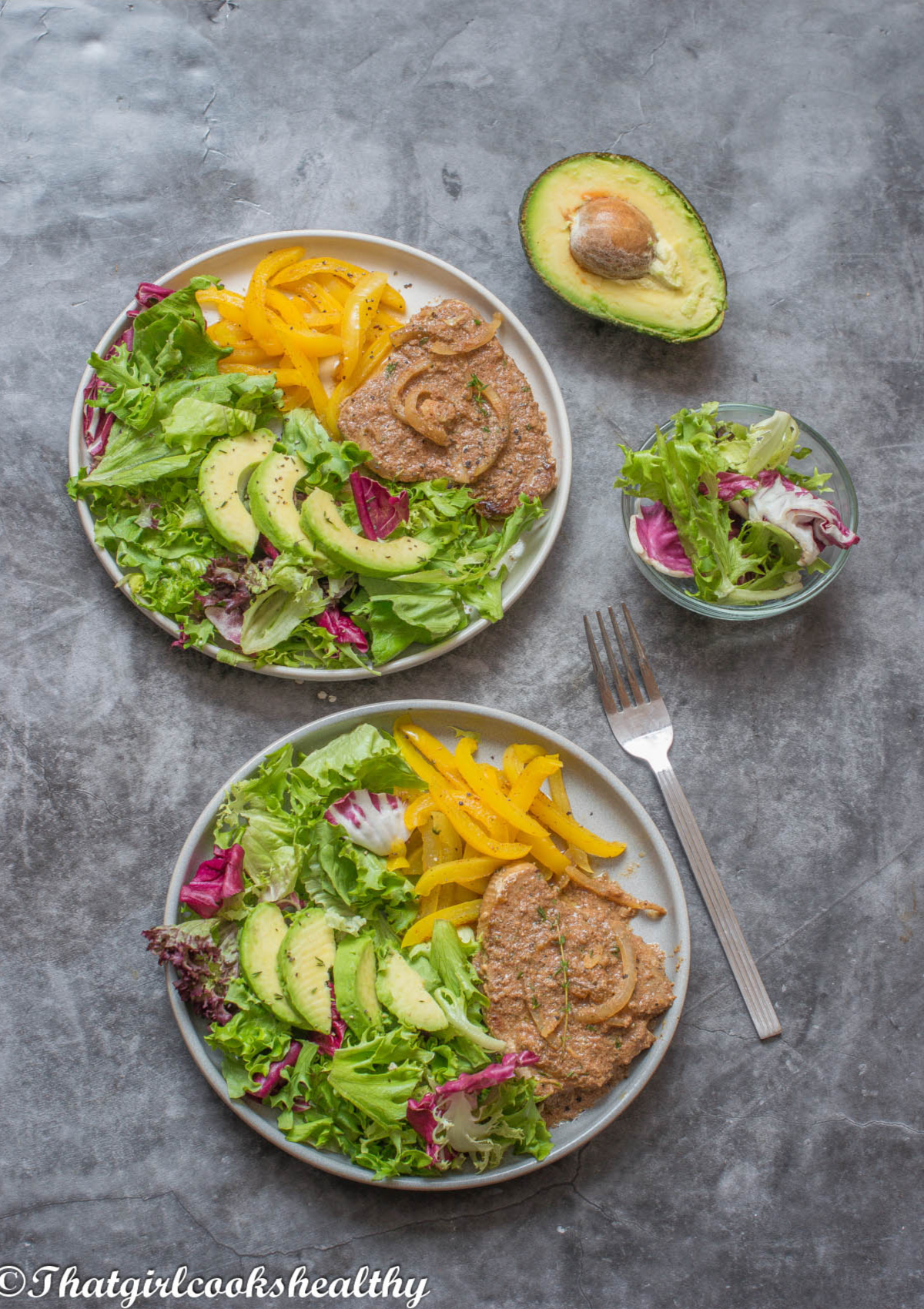 2 plates of tuna steaks with salad, avocado and yellow peppers