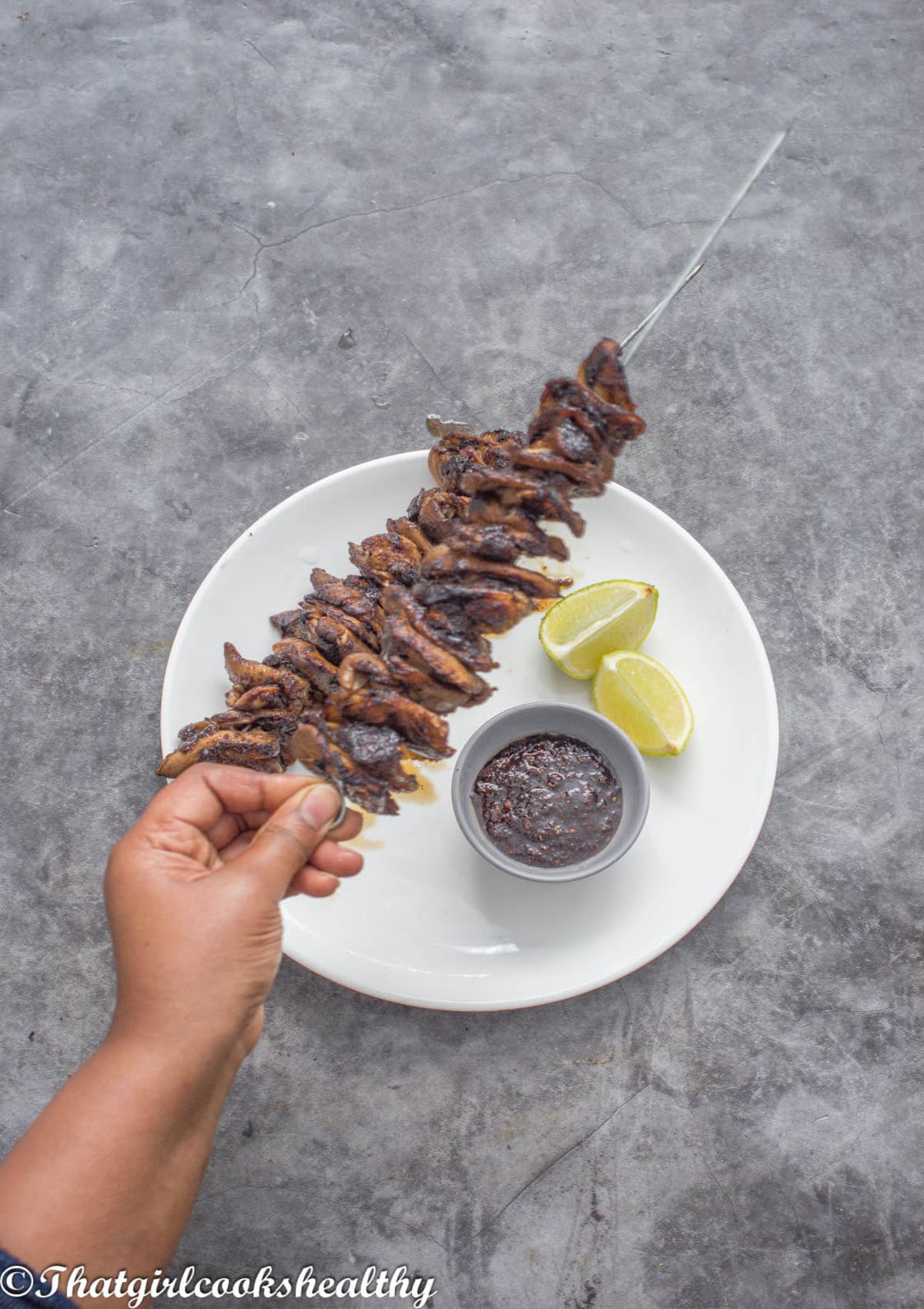 Hand picking up the skewer