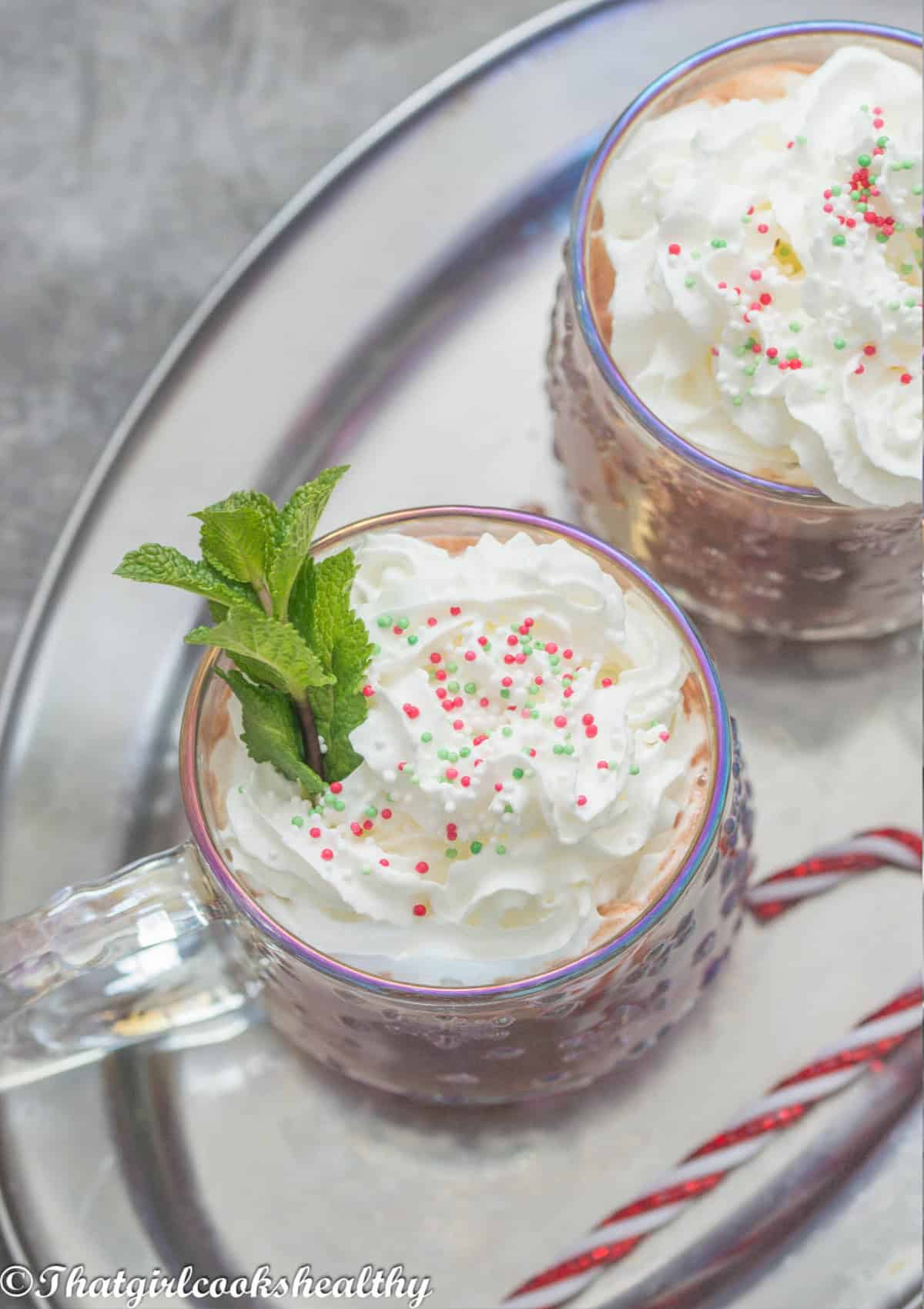 overhead of the mugs of hot chocolate with vegan whipped cream