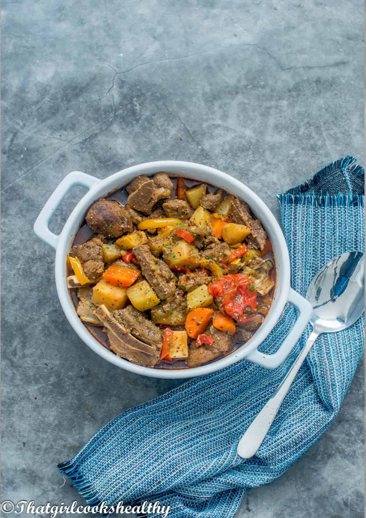 lamb with bright coloured vegetables in a white crockpot