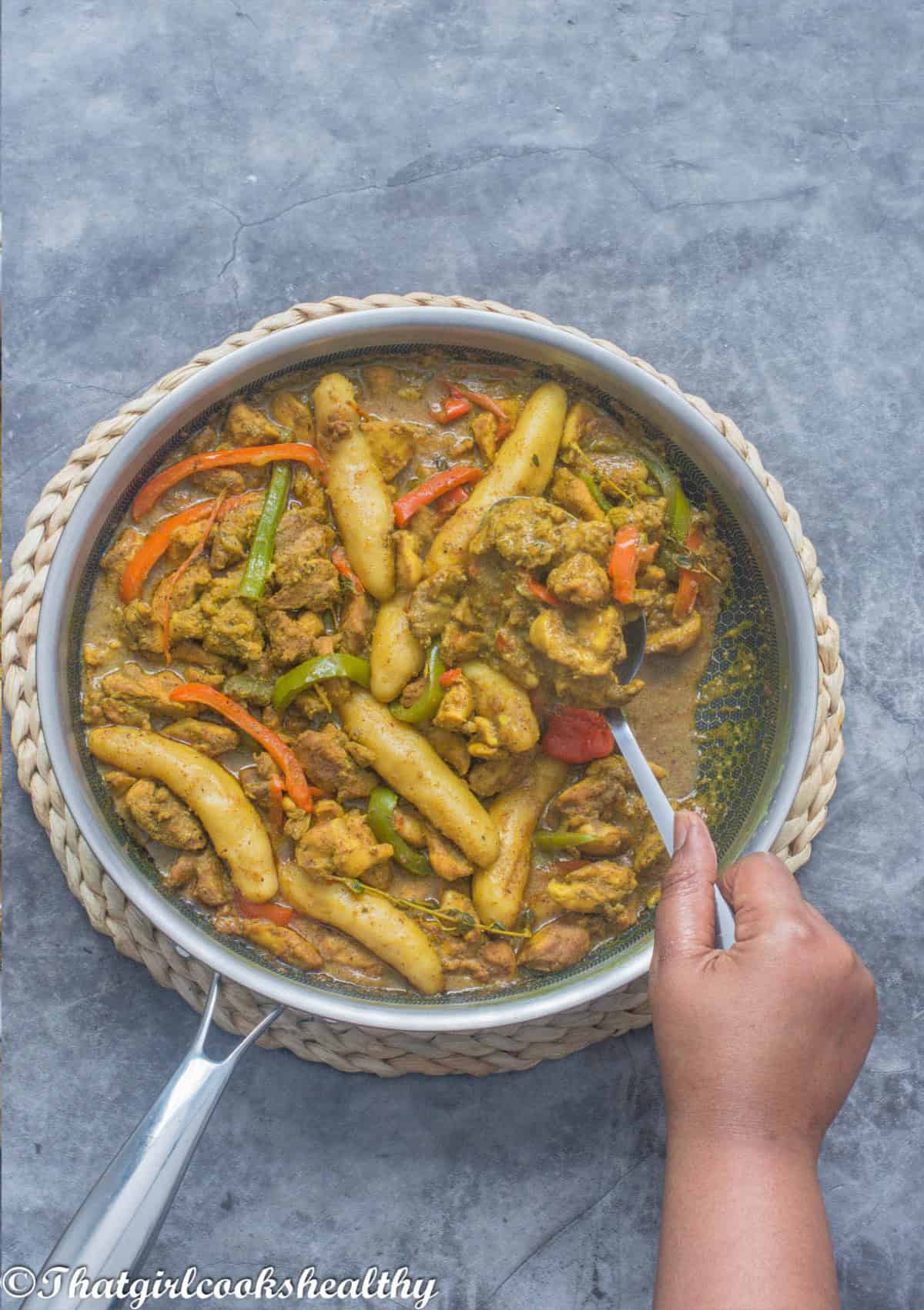 Using a spoon to scoop up some of the curry
