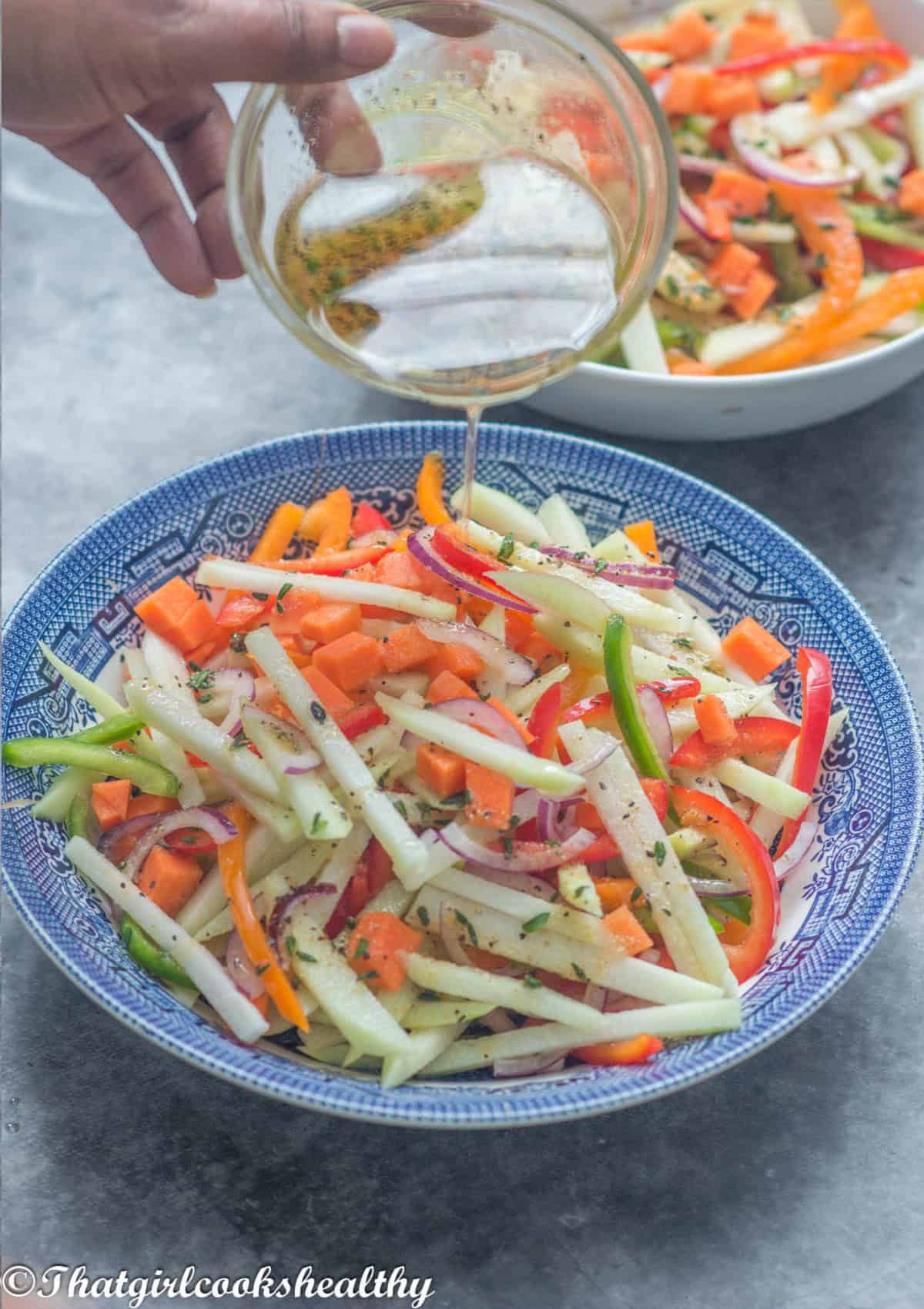 Drizzling dressing over the salad