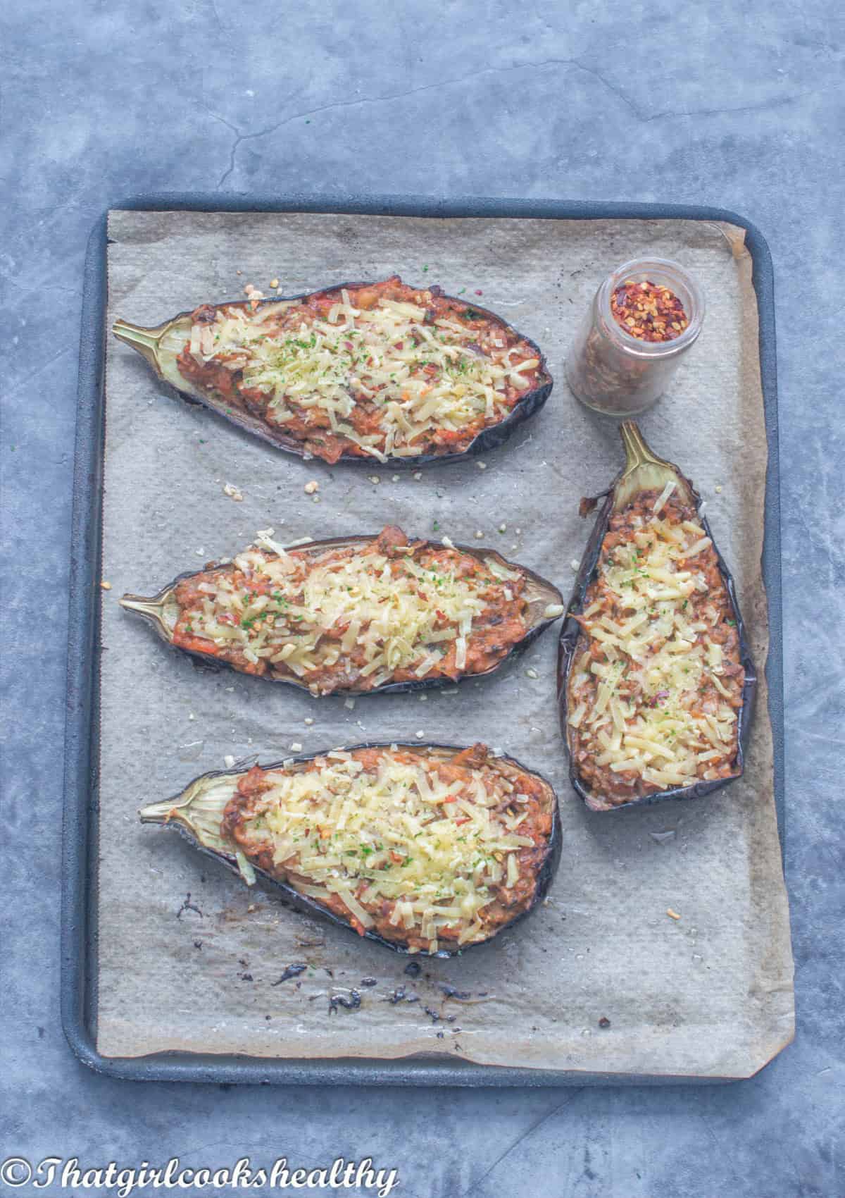 4 eggplants with cheese on a baking tray