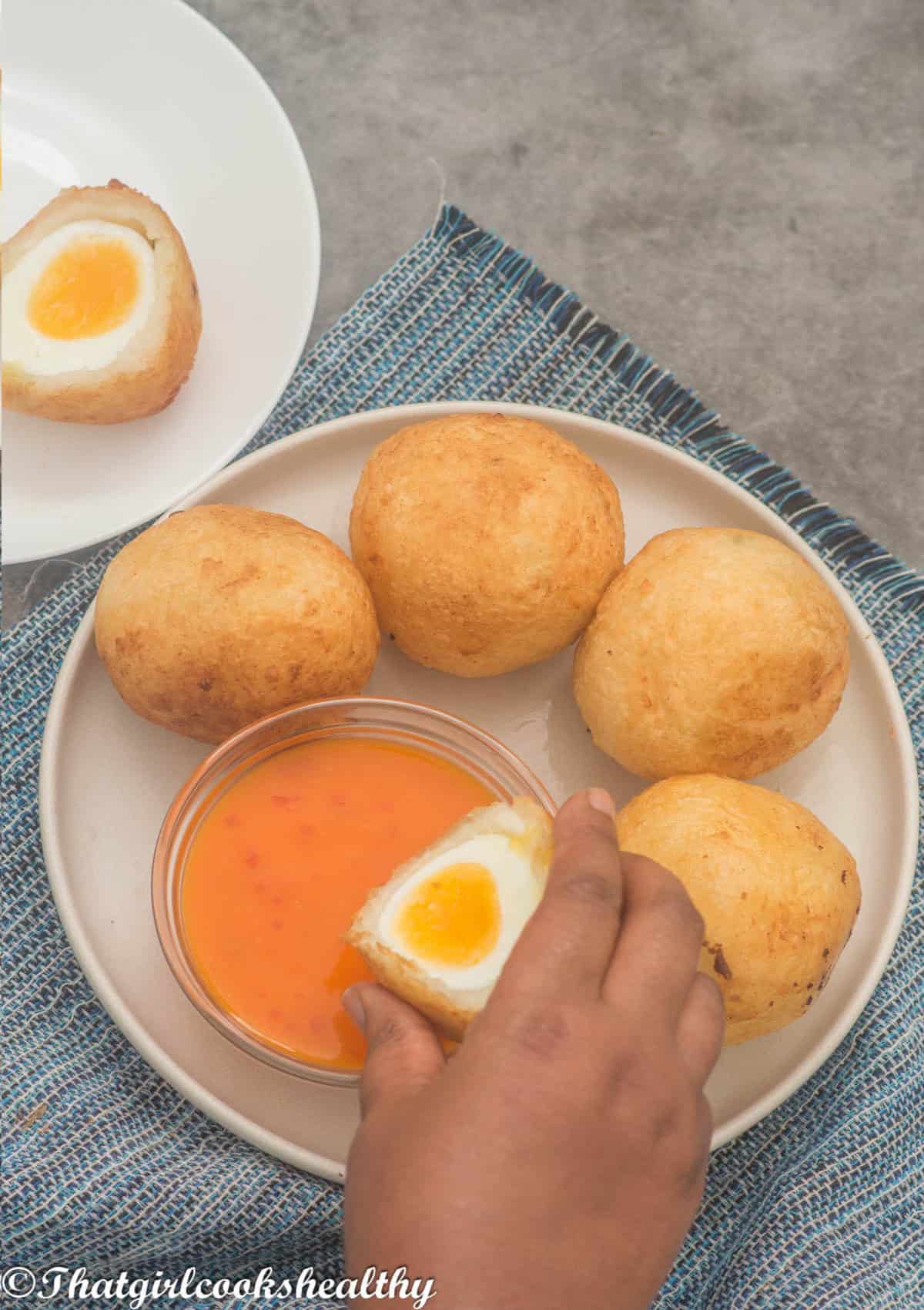 half egg ball dipping into  the sauce