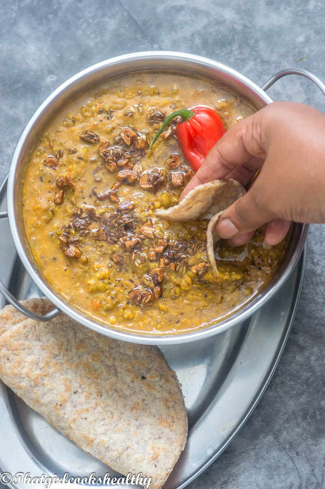 scooping up the dhal with the roti